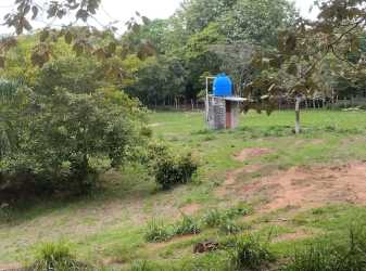 Farm land with small water facility and blue tank surrounded by open grass and trees Calobre Veraguas Panama