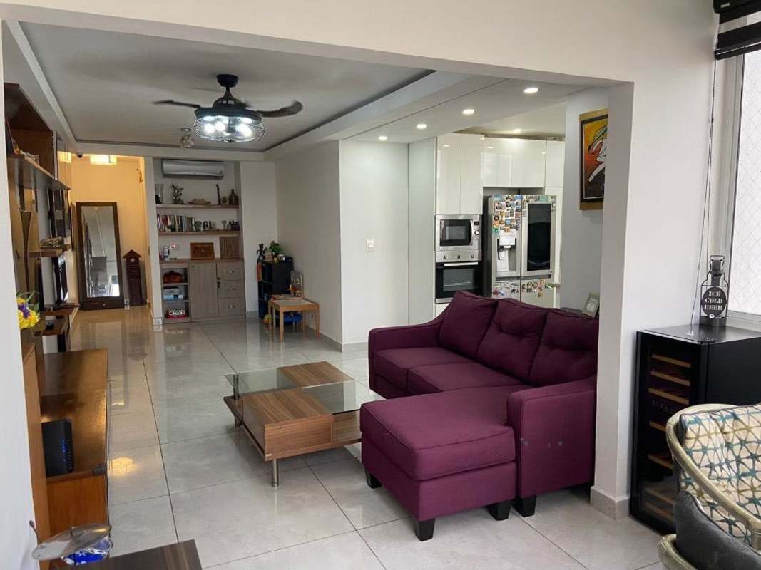 Living room with purple sectional sofa open to kitchen PH San Francisco Condo Panama