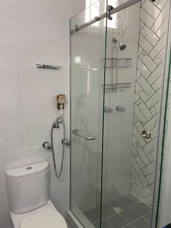 Minimalist bathroom with glass shower enclosure and ceramic tiles Panama