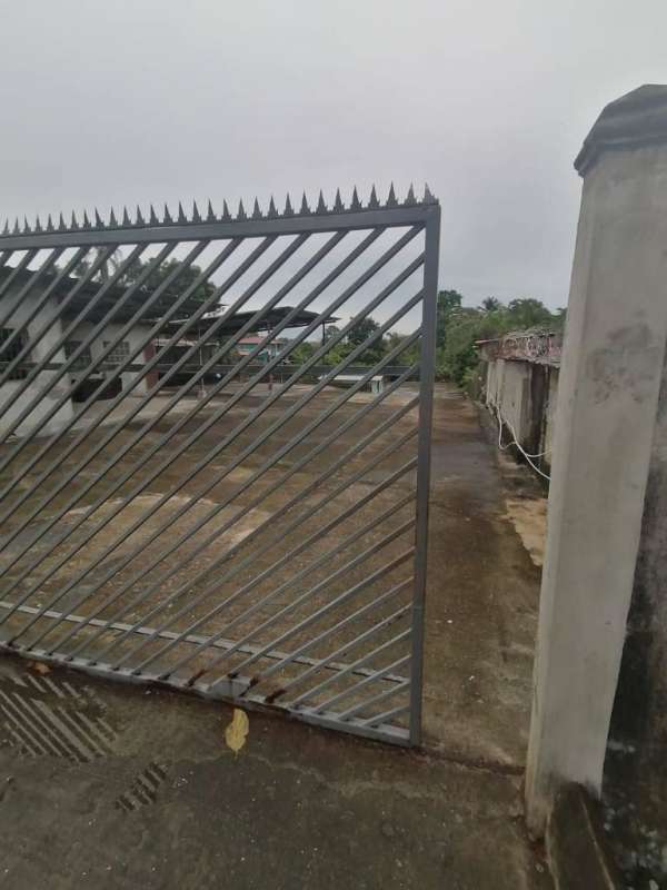 Metal security fence with spiked design and entrance gate for trucks at commercial lot Pedregal Panama