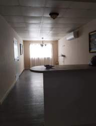 Open plan living and dining space with ceramic tiles and large window in El Palmar Chapala house Arraijan Panama