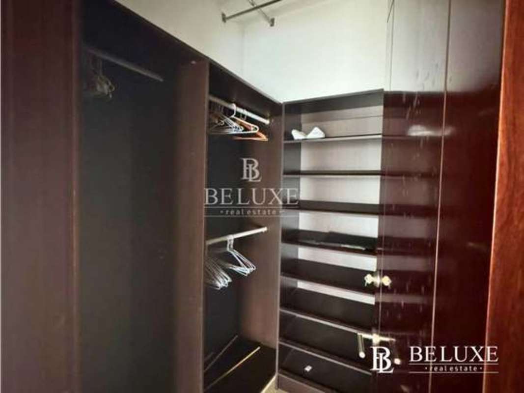 Spacious modern walk-in closet with built-in wood shelving PH Dupont Punta Pacifica
