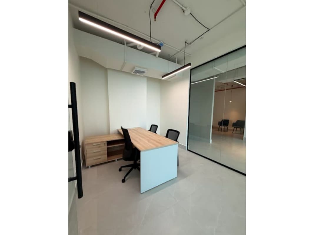 Private office with glass partition walls, wooden desk, exposed ceiling and LED lights in Financial Park Tower Panama City