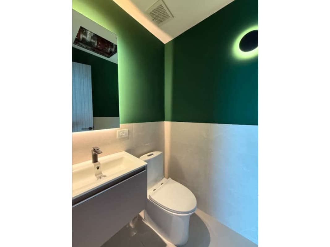 Modern bathroom with green walls, large backlit mirror, stylish toilet at Financial Park Tower Costa del Este
