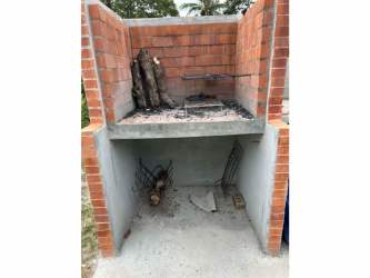 Covered outdoor terrace with rustic barbecue grill and garden in countryside cabin Nueva Gorgona Panama