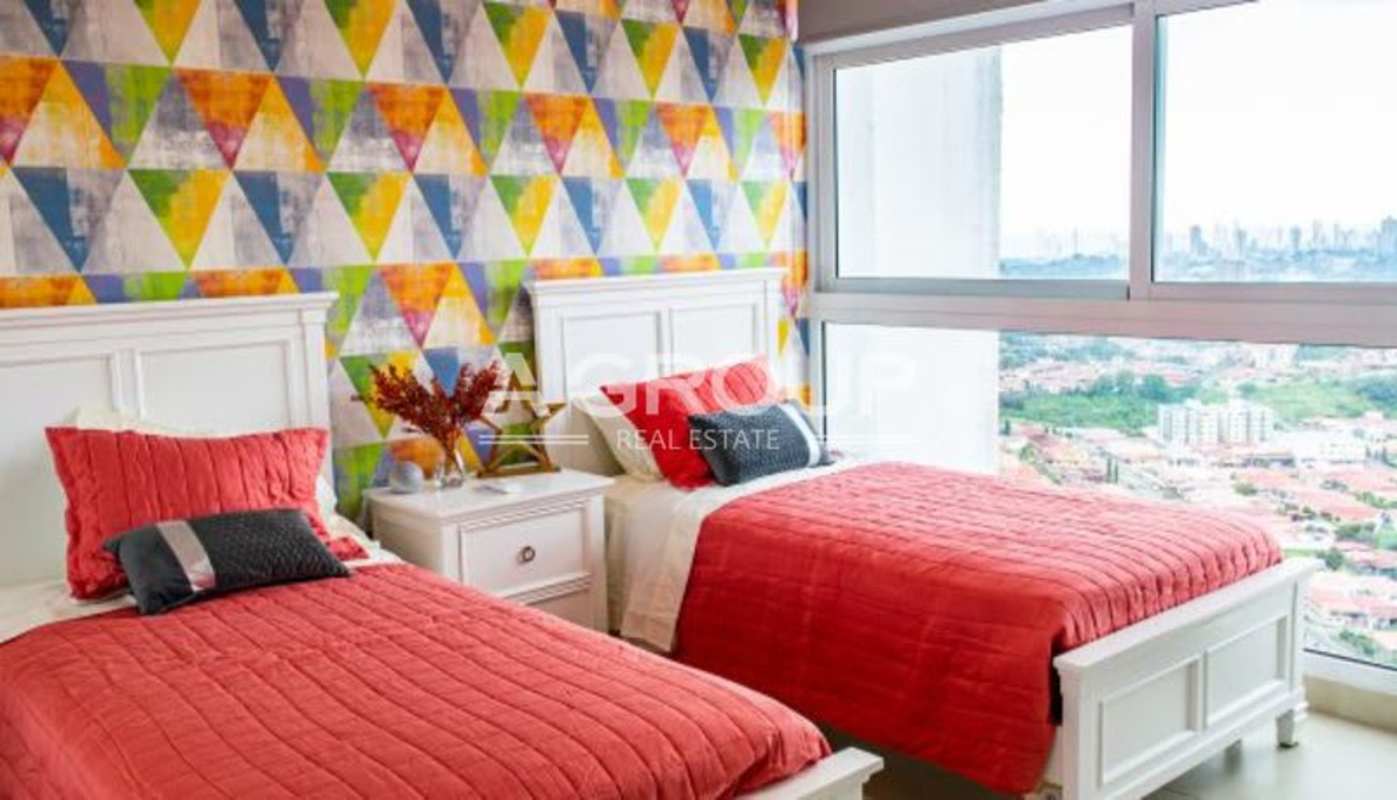 Bedroom with two twin beds, colorful wallpaper, large window overlooking Panama City in PH Country Heights