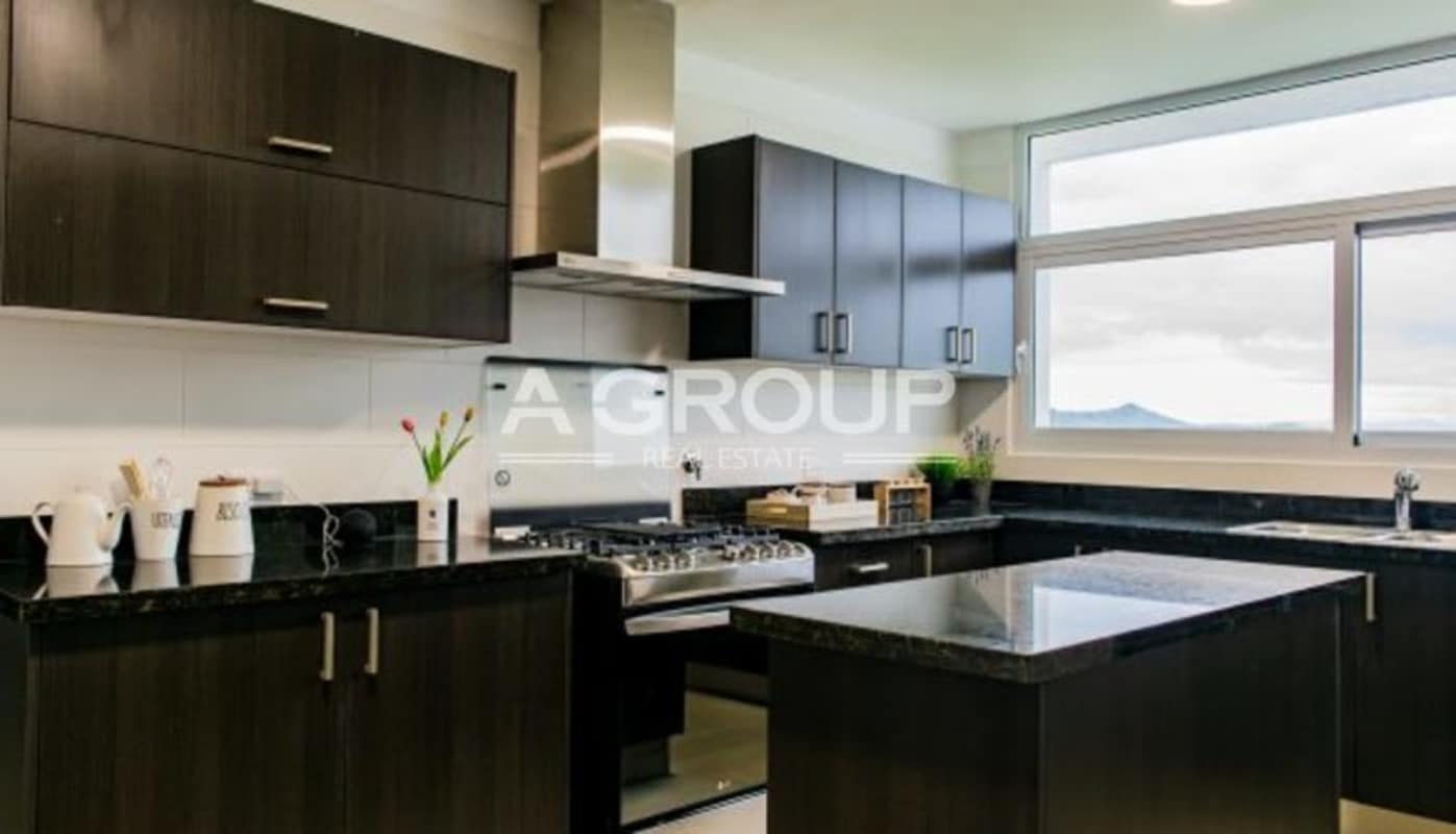 Contemporary kitchen with dark cabinets, black granite island and window mountain views in PH Country Heights Panama City