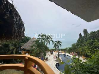 Palapa-roofed lounge area with tropical gardens at beachfront villa Punta Roca Panama