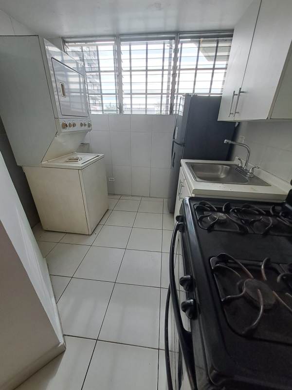 Compact kitchen with laundry area, washer, stove in PH Llano Bonito Don Bosco Panama