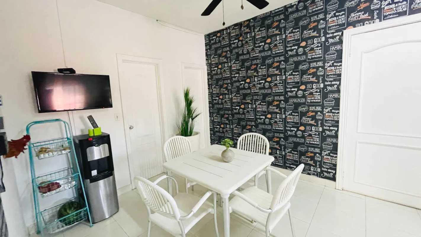 Bright dining space with modern white furniture and wallpaper in PH Torres de Toscana Condado del Rey Panama