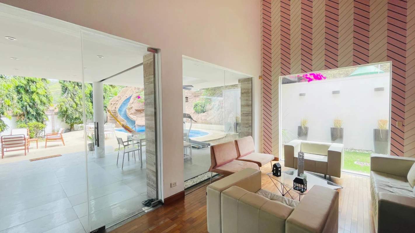 Spacious living area with large windows overlooking garden and pool in PH Torres de Toscana Condado del Rey Panama