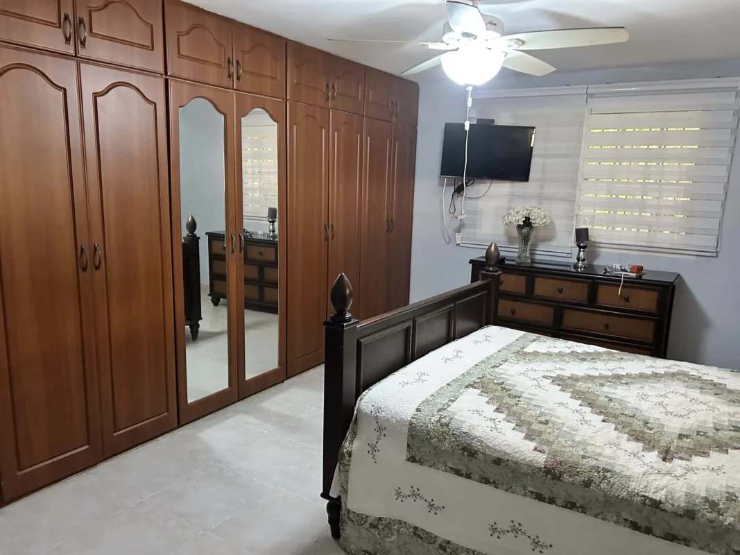 Master bedroom with wooden wardrobes, mirrors and AC in Panama house for sale