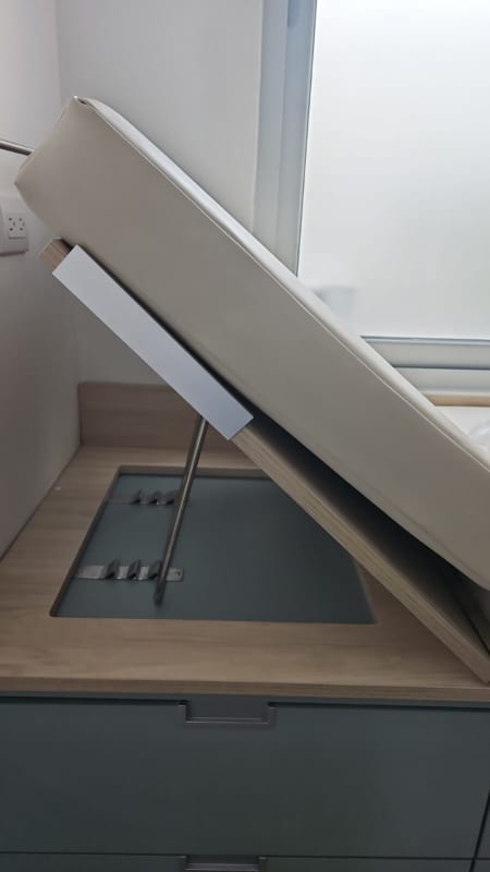 Lift up hydraulic storage bed in modern medical office consultation room