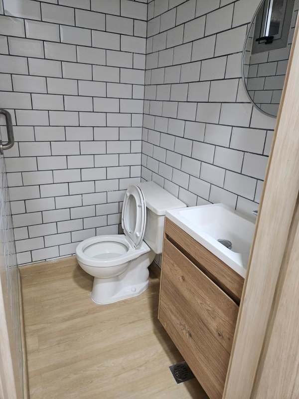 Contemporary bathroom with subway tiles wood vanity and accessibility grab bar