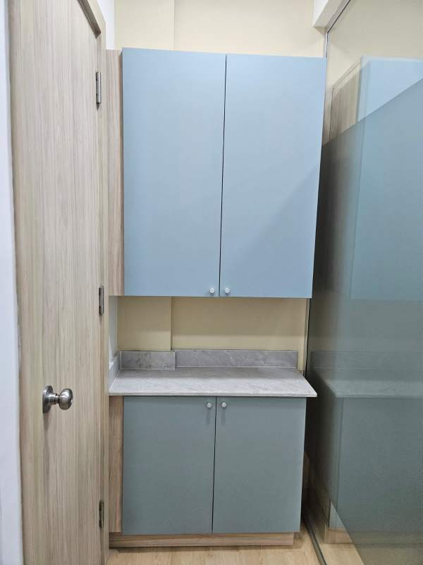 Compact kitchenette or pantry with cabinets and countertop inside medical office