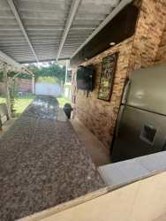 Covered gazebo lounge next to pool surrounded by palm trees at Nueva Gorgona Coronado beach home for sale