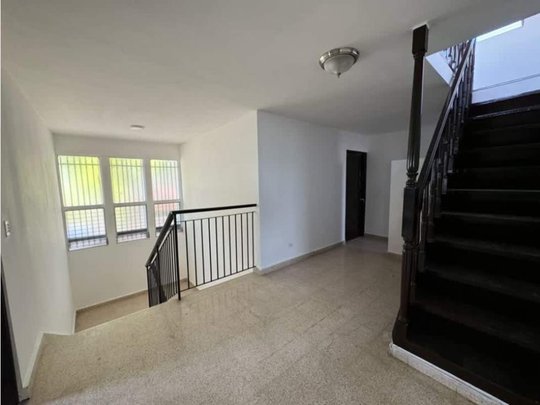 Interior stairwell with barred windows metal rail and beige tile in 2-story house Bethania Panama
