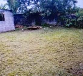 Large fenced backyard with grass and trees behind house in Valle Hermoso Nuevo Arraiján Panama