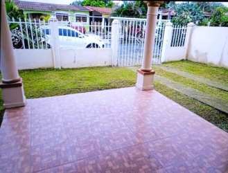 Side exterior showing fenced yard grassy lawn suburban home Valle Hermoso Arraiján Panama