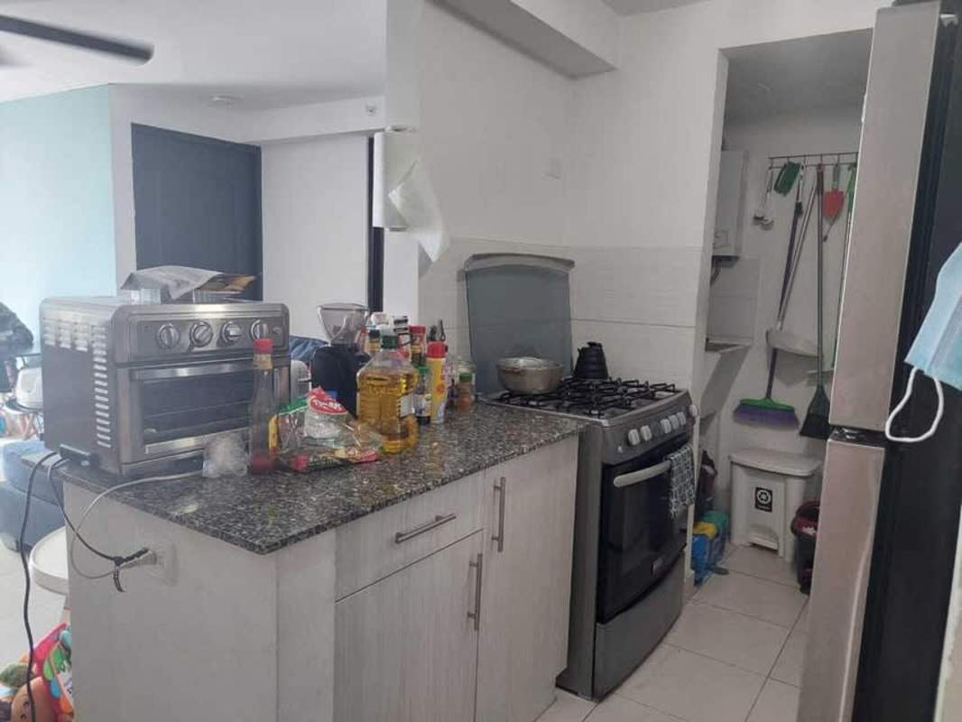 Modern kitchen with granite countertop and stainless appliances in PH Riverside Panama City apartment for sale