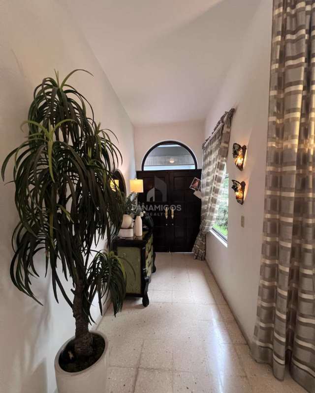 Traditional dining room with chandelier, elegant furniture and natural lighting in El Carmen Bella Vista home Panama