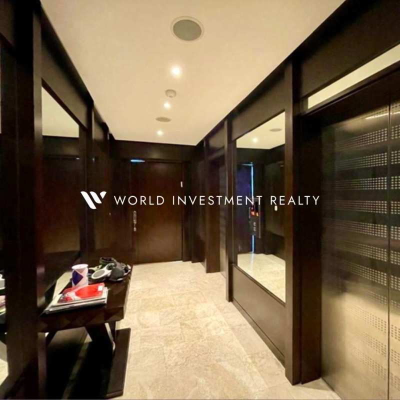 Contemporary kitchen with granite countertops, wooden cabinetry and stainless steel appliances in PH Aquamare apartment