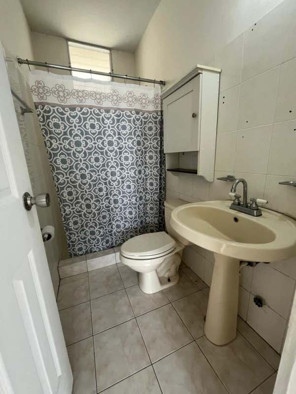 Bathroom featuring pedestal sink, toilet, and wall cabinet at PH Las Roccas Panama City