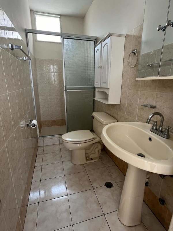 Traditional bathroom with pedestal sink and glass shower door in PH Las Roccas Panama City