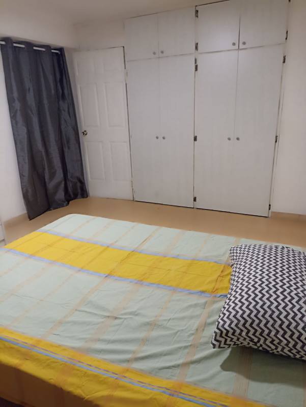 Minimalist bedroom with built-in wardrobe, light blue and yellow bedding at PH Obarrio Suites Panama City.