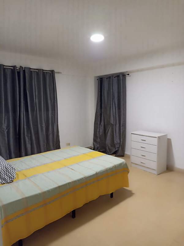 Bedroom with light blue blanket, curtains PH Obarrio Suites near Vía España Panama City.