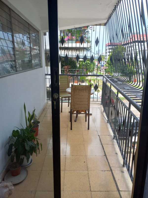 Balcony with security grilles tiled floor table chairs plants in Obarrio rental building.