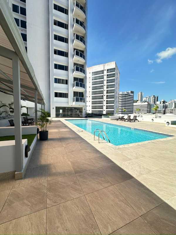 Outdoor rooftop swimming pool with lounge area and skyline view at PH Denovo Panama City