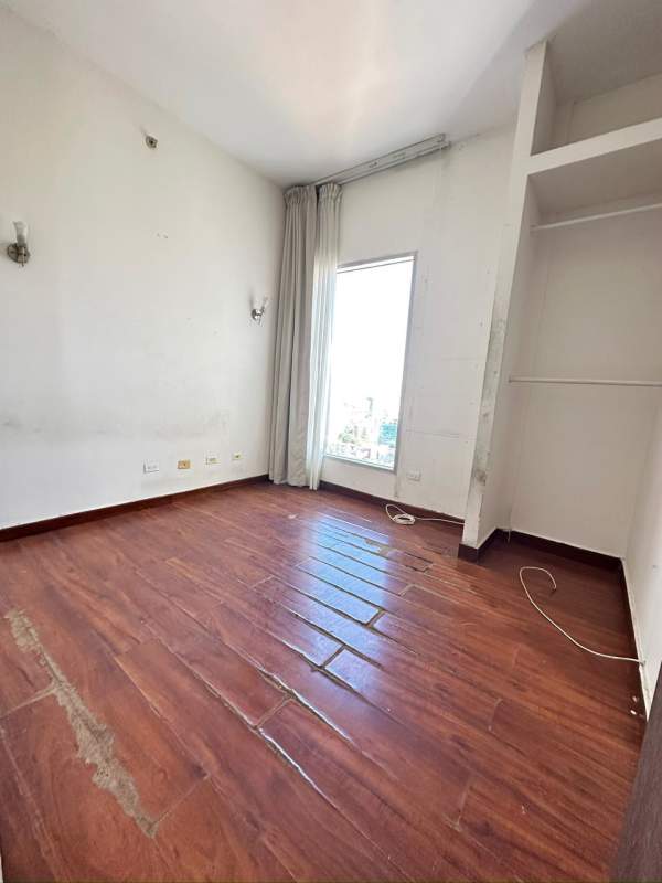 Bedroom with built-in closet, large window and city skyline views in PH Denovo Obarrio Panama