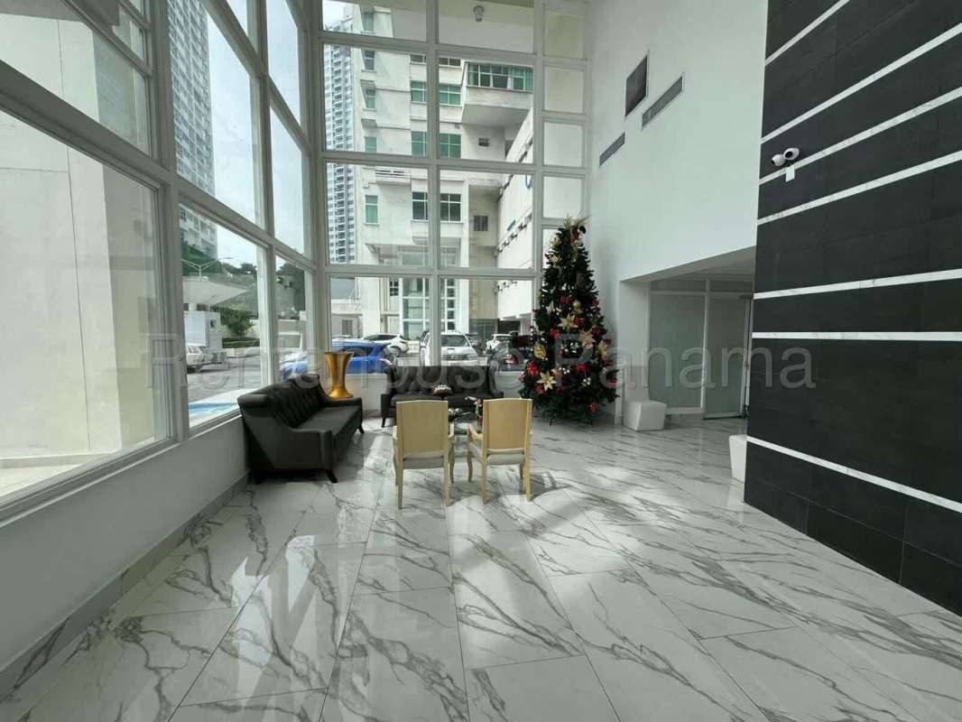 Double-height lobby with marble-look flooring and modern seating at PH Edison Park Tower