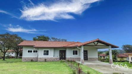 Red tiled roof house with covered carport stone accents landscaped yard in Boquete
