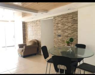Dining space with wood ceiling panels stone wall glass table PH Silver City Panama Portobelo