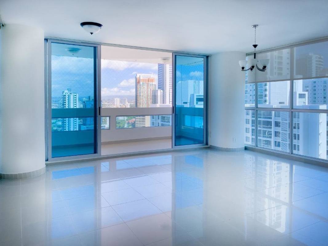 Spacious living dining area with floor-to-ceiling windows, balcony access, and city skyline panorama at Vista del Mar Panama