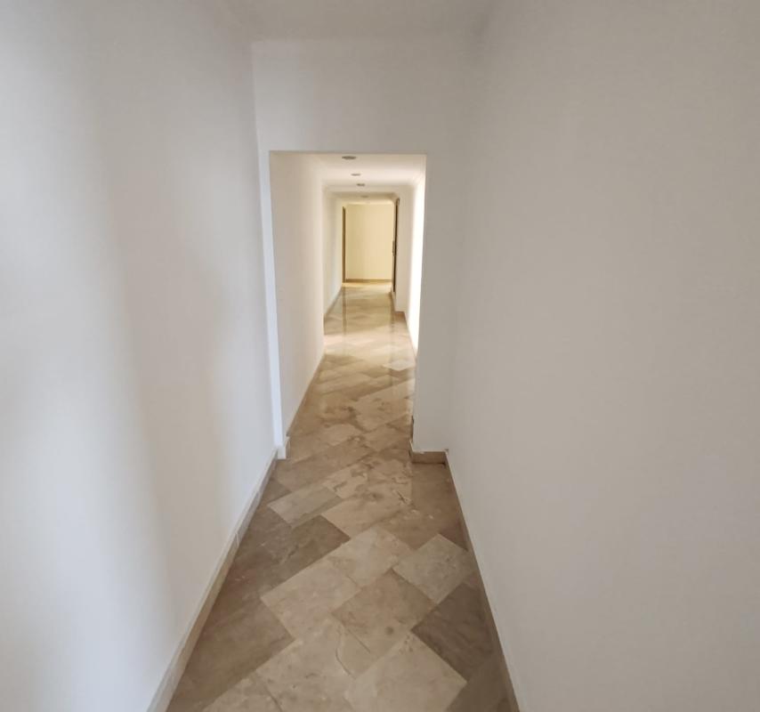 Spacious interior hallway with marble tile floors and recessed lighting