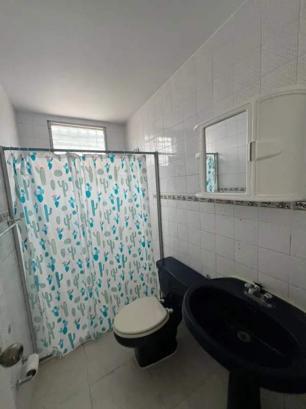 Bathroom with white tiles, shower, and mirror cabinet remodeled Brisas del Golf house