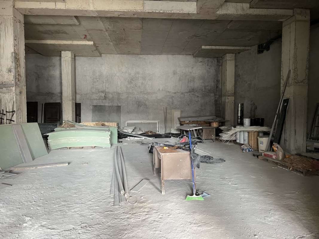 Interior commercial corridor with glass shop windows and wood accents at Transistmica Business Plaza Panama City