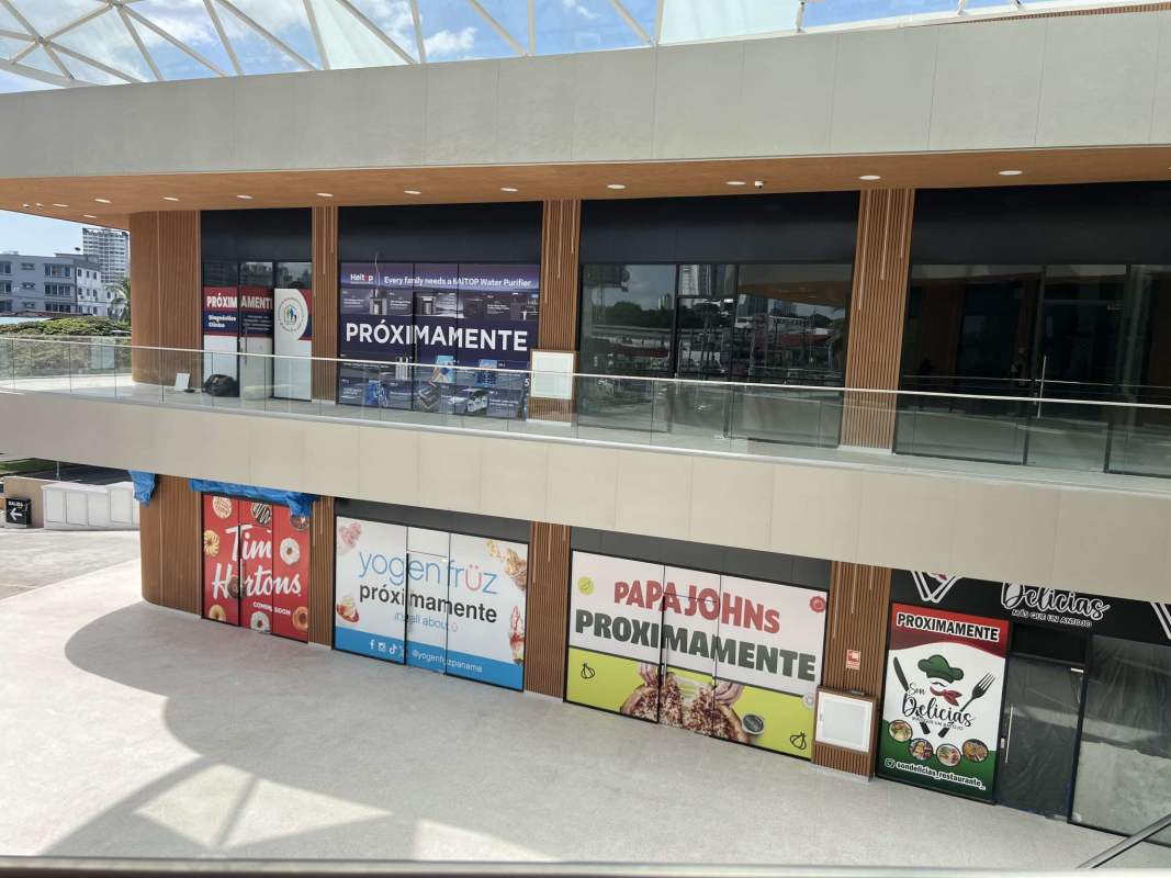 View of Panama City main road with palm trees and mall entrance at Via Transistmica Pedregal area