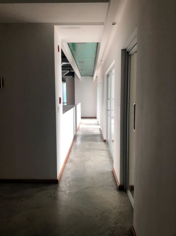 Office corridor glass sliding doors recessed lights exposed ceiling PH BICSA Panama City