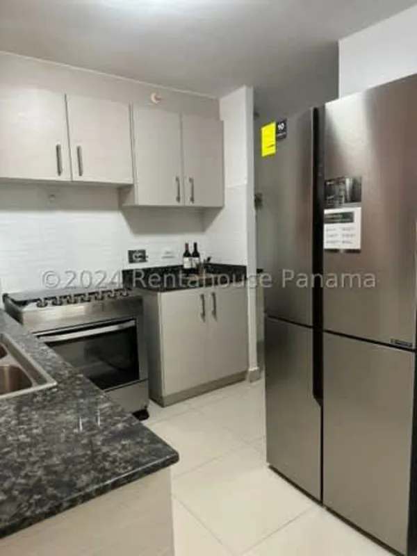 Modern kitchen with granite counter, fridge, stove, white cabinets rented apartment Carrasquilla