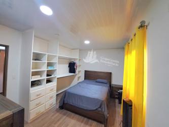 Furnished bedroom with built-in closet and wooden floor in Boquete Panama home