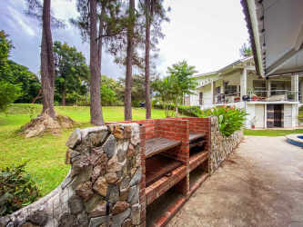 Expansive backyard with barbecue pavilion grassy yard trees two-story balcony Santa Clara Panama beach villa