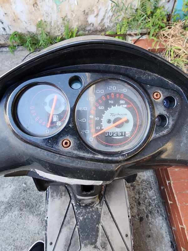 Small urban house exterior in El Dorado with barred windows, planted courtyard and Piaggio scooter at property