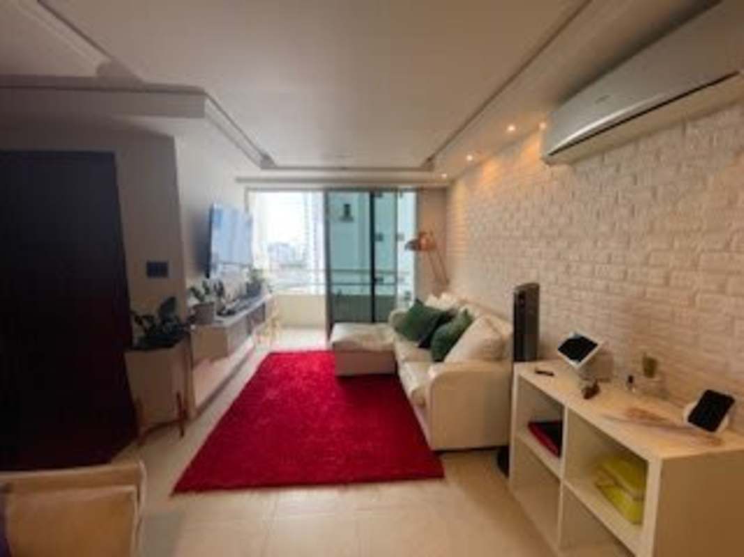 Open-plan living room with balcony, white brick wall and tile floors at PH Splendor by The Park Via España Panama