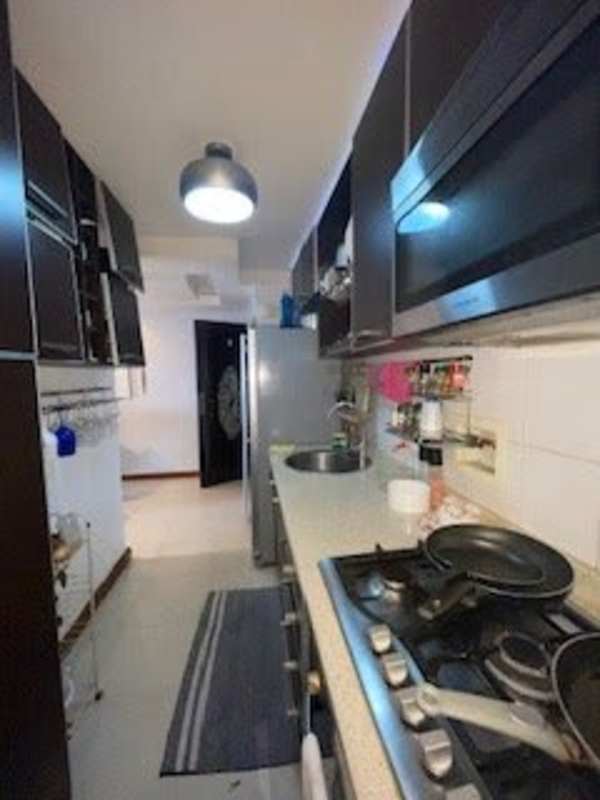 Galley kitchen with overhead cabinets, gas stove, and tile backsplash at PH Splendor by The Park Via España Panama