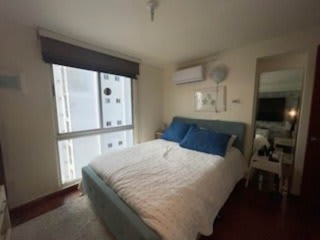 Bright bedroom with blue bed, window, AC and mirrored closet at PH Splendor by The Park Via España Panama City