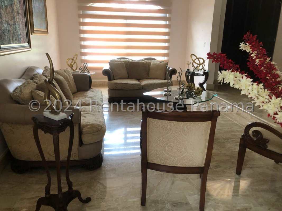 Formal dining room with ornate wooden furniture, chandelier, marble floor in luxury Costa del Este house